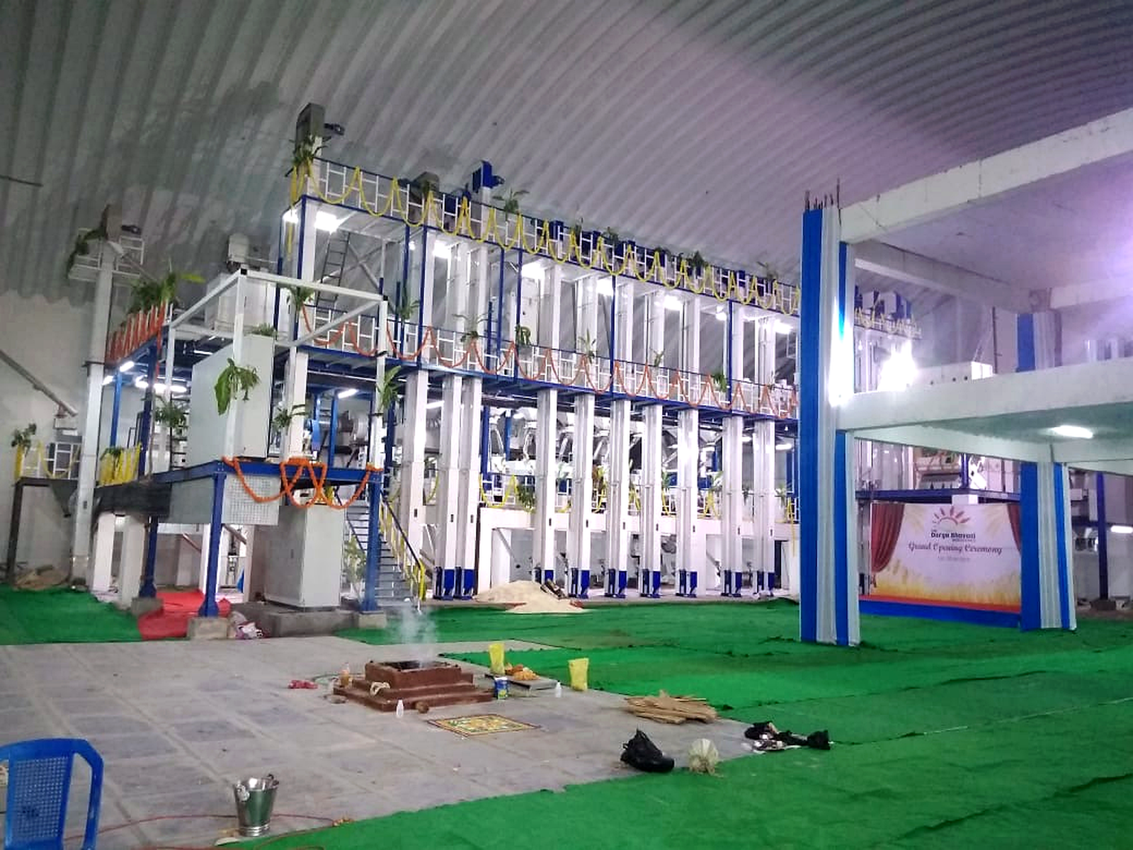Manufacturing facility showing industrial production equipment beneath a large factory roof structure.