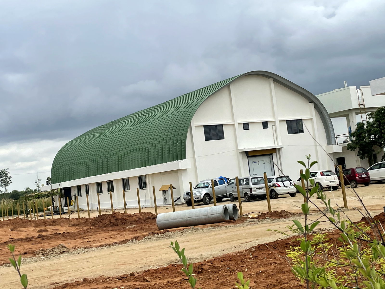 Industrial manufacturing building with a large curved roof and factory-scale exterior.