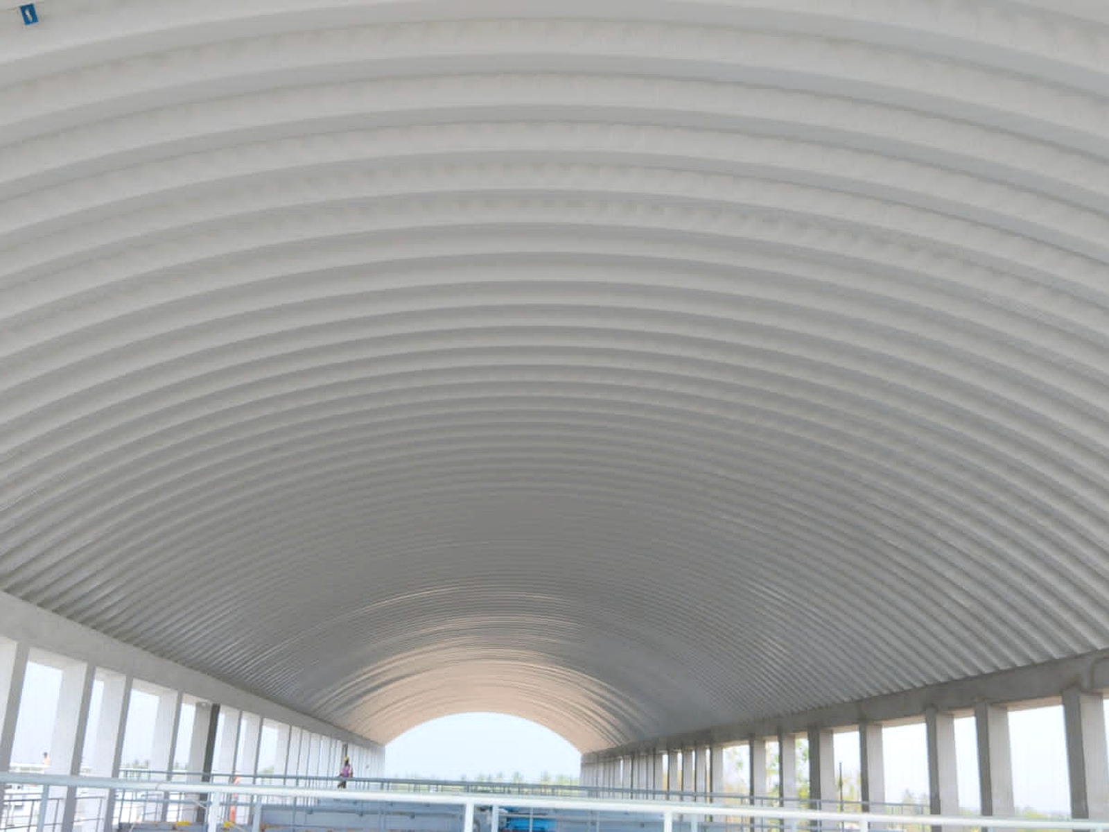 Large covered hall showing a clear-span interior beneath an arched roof structure.