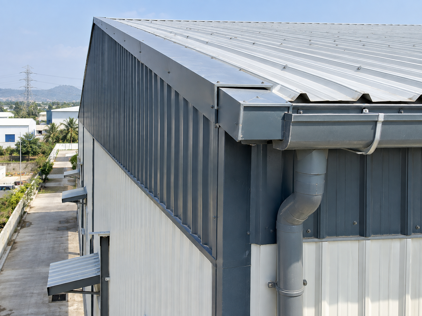 Close architectural view showing the roof edge, eaves, gutter, flashing and wall cladding interface.