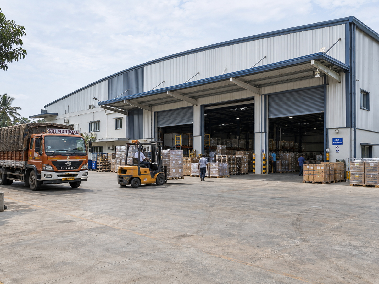 Operational industrial steel building with loading areas, vehicles and active warehouse use.