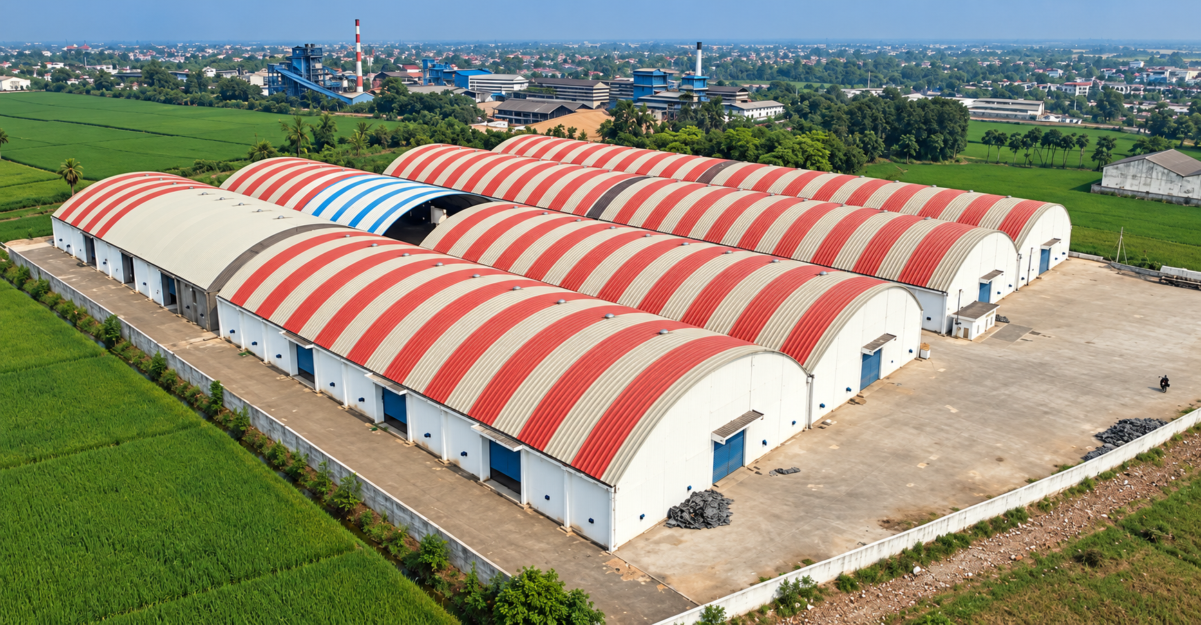 Multiple curved trussless roofing spans on industrial buildings